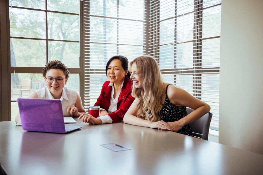 group of people discuss something while looking at computer screen